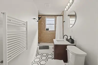 a bathroom with a toilet and a sink and a mirror at The Bella Vista Townhouse in Philadelphia