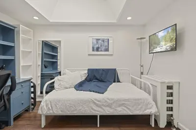 a bedroom with a bed and a tv on a wall at The Bella Vista Townhouse in Philadelphia