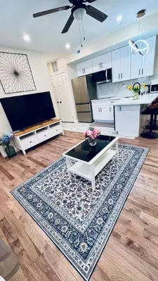 a living room with a table and a kitchen at Renovated Modern Apt next to ChinatownConvention in Philadelphia