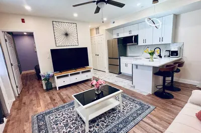 a large kitchen and living room with a flat screen tv at Renovated Modern Apt next to ChinatownConvention in Philadelphia