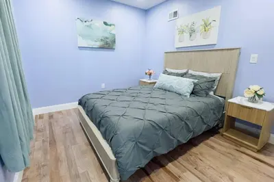 a bedroom with a large bed with blue walls at Renovated Modern Apt next to ChinatownConvention in Philadelphia