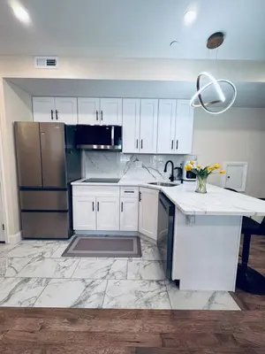 a kitchen with white cabinets and a marble counter top at Renovated Modern Apt next to ChinatownConvention in Philadelphia
