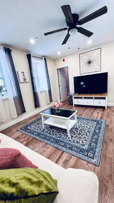 a living room with a couch and a flat screen tv at Renovated Modern Apt next to ChinatownConvention in Philadelphia