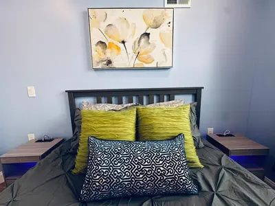 a bedroom with a bed with yellow pillows and two tables at New Apt w Washer Dryer Kitchen Rainfall in Chinatown in Philadelphia
