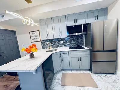 a kitchen with white cabinets and a sink and a refrigerator at New Apt w Washer Dryer Kitchen Rainfall in Chinatown in Philadelphia
