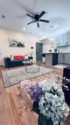 a living room with a couch and a table with flowers at Brand New Apt w Washer Dryer Kitchen Rainfall in Chinatown in Philadelphia