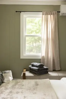 a bedroom with a window and a pile of towels at Cozy Cottage in Glen Spey in Glen Spey