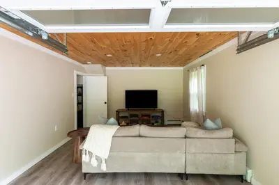 a living room with a couch and a flat screen tv at Cozy Cottage in Glen Spey in Glen Spey