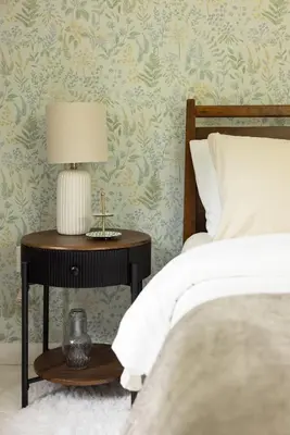 a bedroom with a bed and a table with a lamp at Cozy Cottage in Glen Spey in Glen Spey