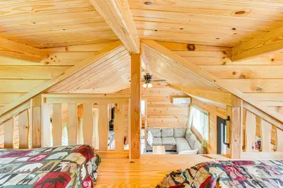a log cabin with two beds and a couch at 5 Mi to Susquehanna Boating! Secluded Log Cabin