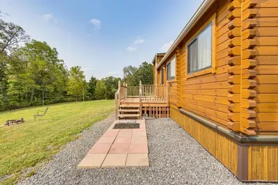 a log cabin with a porch and a deck at 5 Mi to Susquehanna Boating! Secluded Log Cabin