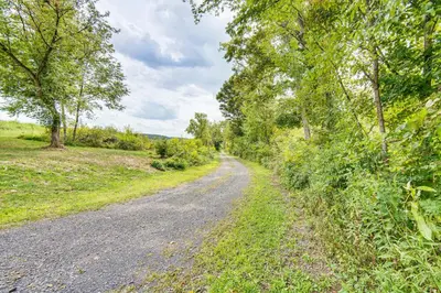 a dirt road with trees on either side at 5 Mi to Susquehanna Boating! Secluded Log Cabin