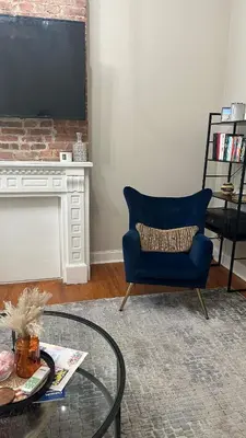 a living room with a blue chair and a table at Modern Comfort 1BR in Jersey City in Jersey City