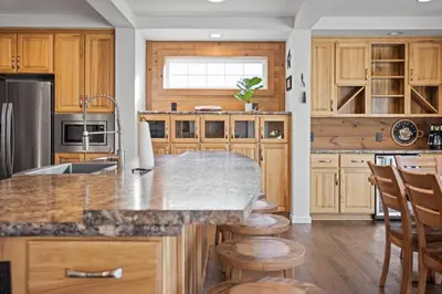 a kitchen with wooden cabinets and a marble counter top at Tioga's Peaceful Gem