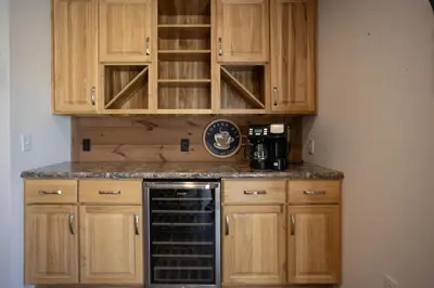 a kitchen with wooden cabinets and a black dishwasher at Tioga's Peaceful Gem