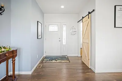 a hallway with white walls and a door with a rug at Tioga's Peaceful Gem