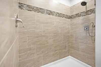 a bathroom with a shower with beige tiles at Tioga's Peaceful Gem