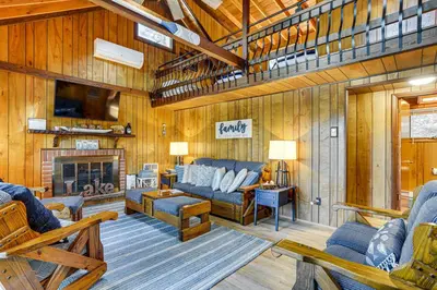 a living room with a couch and a fireplace at Less Than 1 Mi to Lake Cabin with Hot Tub in Greentown! in Greentown