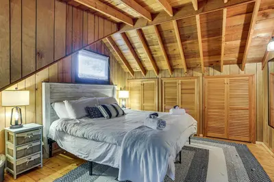 a bedroom with a bed in a room with wooden walls at Less Than 1 Mi to Lake Cabin with Hot Tub in Greentown! in Greentown