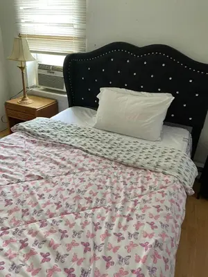 a bed with a floral comforter and a pillow at 2131 Double Room with Private Bathroom in Philadelphia