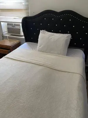 a white bed with a black headboard and a white pillow at 2131 Double Room with Private Bathroom in Philadelphia