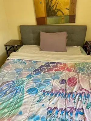a bed with a colorful comforter on top of it at 2131 queen room With shared Bathroom in Philadelphia