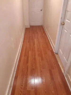 a hallway with a wooden floor and a door at 2131 queen room With shared Bathroom in Philadelphia