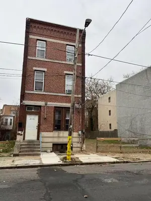 a brick building with a yellow pole in front of it at 2131 queen room With shared Bathroom in Philadelphia