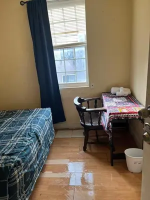 a bedroom with a bed and a table and a window at 2131 queen room With shared Bathroom in Philadelphia