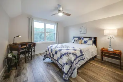 a bedroom with a bed and a desk and a window at Waterfront Home with Kayaks, Trails and Petting Zoo!