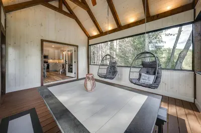a room with two wicker chairs and a table at Waterfront Home with Kayaks, Trails and Petting Zoo!