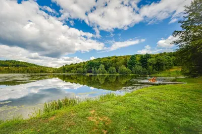 a boat on a lake on a cloudy day at Waterfront Home with Kayaks, Trails and Petting Zoo!