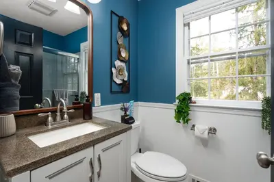 a bathroom with a toilet and a sink and a window at Exclusive Lux Home Near Town • Game Rm • Gym • 4BR in Princeton
