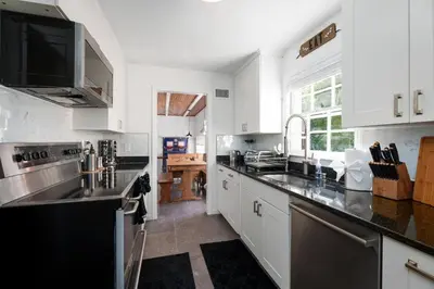 a kitchen with white cabinets and black counter tops at Exclusive Lux Home Near Town • Game Rm • Gym • 4BR in Princeton
