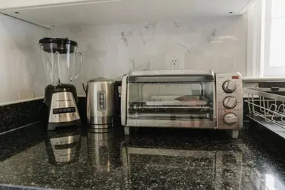 a toaster oven sitting on a counter in a kitchen at Exclusive Lux Home Near Town • Game Rm • Gym • 4BR in Princeton