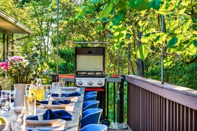 a table with blue chairs and an oven on a patio at Large Group Friendly 2 Game Rooms Indoor Sauna Hot Tub Near Jack Frost Ski Resort in Blakeslee