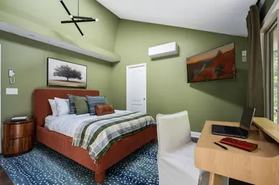 a bedroom with a bed and a desk with a laptop at Large Group Friendly 2 Game Rooms Indoor Sauna Hot Tub Near Jack Frost Ski Resort in Blakeslee