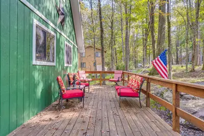 a group of chairs on a wooden deck with an american flag at Fishing, Fun and Fall Foliage! Pocono Lake Cabin in Pocono Lake