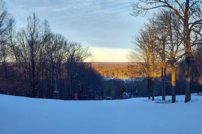 a snow covered field with trees in the distance at Fishing, Fun and Fall Foliage! Pocono Lake Cabin in Pocono Lake