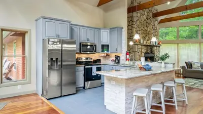a kitchen with stainless steel appliances and a stone wall at Lake Harmony Chalet w Hot Tub Arcades Near Beaches Ski Trails Everpine Lodge by AvantStay in Lake Harmony
