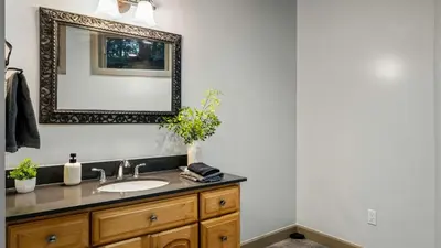 a bathroom with a sink and a mirror at Lake Harmony Chalet w Hot Tub Arcades Near Beaches Ski Trails Everpine Lodge by AvantStay in Lake Harmony