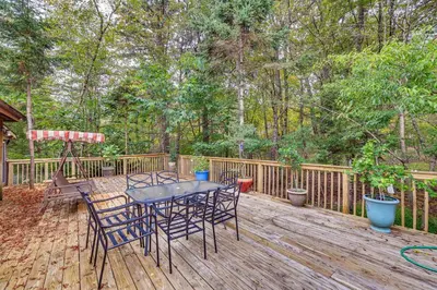 a patio with a table and chairs on a wooden deck at 7 Mi to Big Boulder Mtn! Home with Pet-Friendly Yard in Towamensing Trails