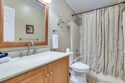 a bathroom with a sink and a toilet and a mirror at 7 Mi to Big Boulder Mtn! Home with Pet-Friendly Yard in Towamensing Trails