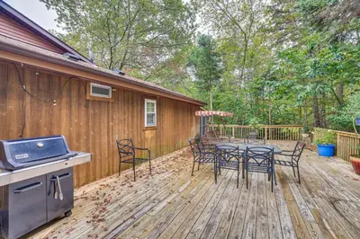 a patio with a table and chairs on a wooden deck at 7 Mi to Big Boulder Mtn! Home with Pet-Friendly Yard in Towamensing Trails