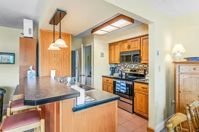 a kitchen with wooden cabinets and a counter top at Epic Views and Pool Access! Gem on Big Boulder Lake in Lake Harmony