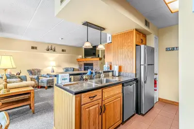 a kitchen with a sink and a refrigerator at Epic Views and Pool Access! Gem on Big Boulder Lake in Lake Harmony