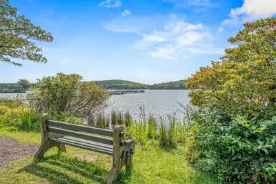 a park bench sitting next to a body of water at Epic Views and Pool Access! Gem on Big Boulder Lake in Lake Harmony