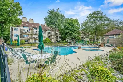 a pool with tables and chairs and a hotel at Epic Views and Pool Access! Gem on Big Boulder Lake in Lake Harmony