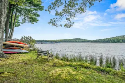 a park bench next to a lake with a boat at Epic Views and Pool Access! Gem on Big Boulder Lake in Lake Harmony