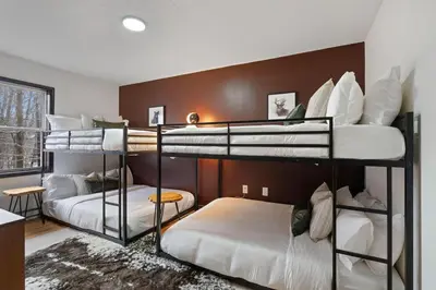 a room with three bunk beds in a house at Cozy Poconos Retreat - pool table, hot tub, fire pit in Tobyhanna